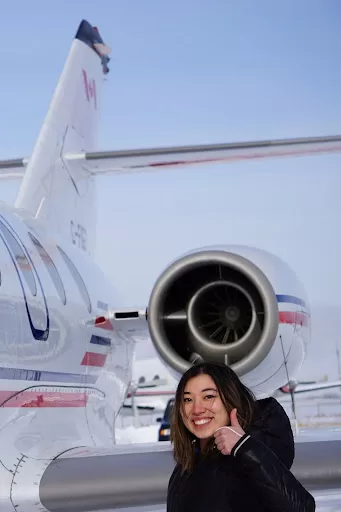 Photo of Makenna in front of airplane