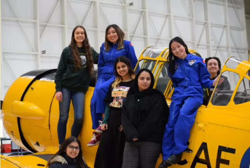 Photo of student team on yellow aircraft